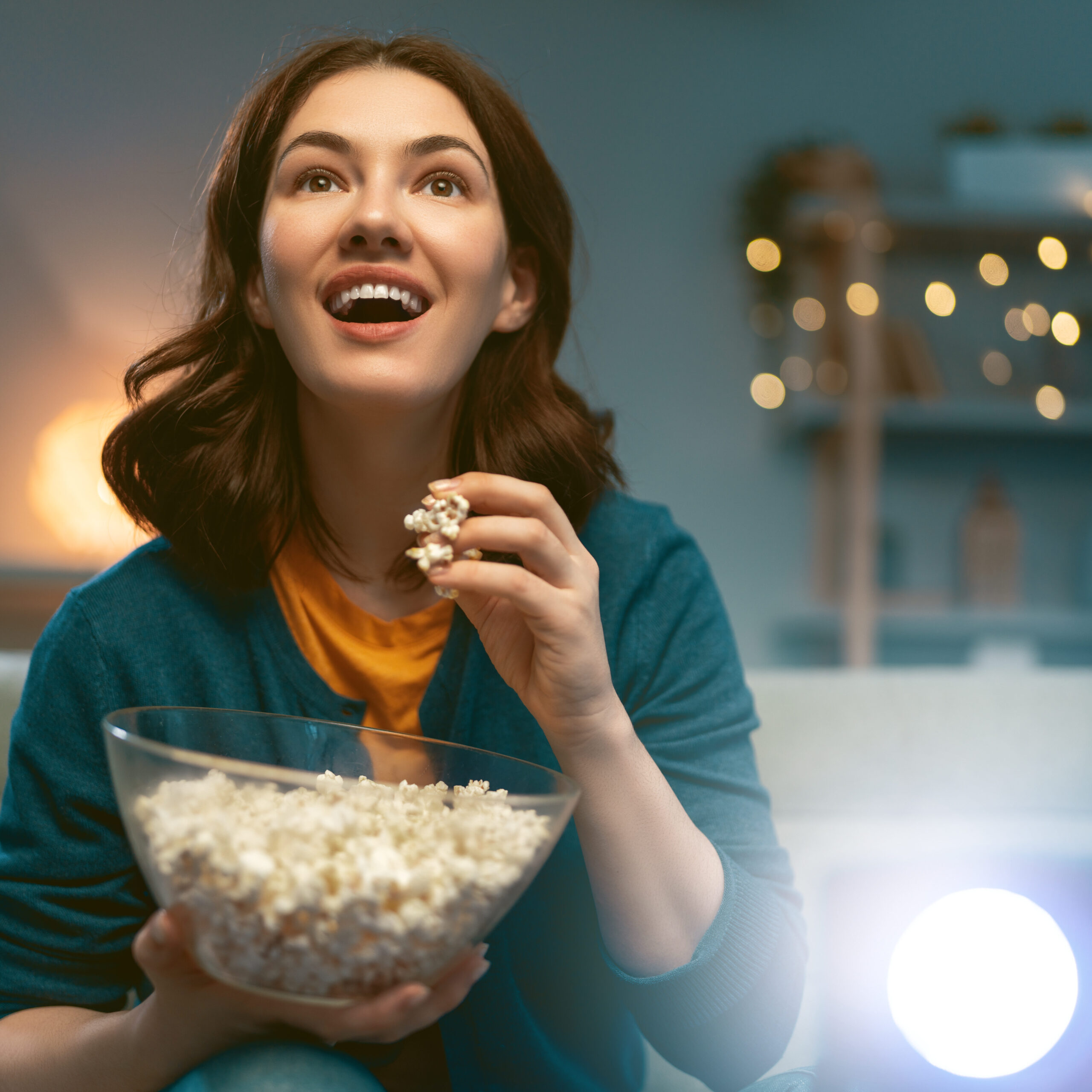 Young woman watching projector, TV, movies